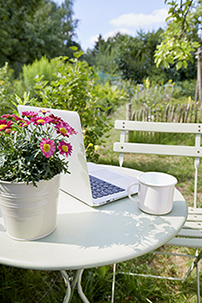 Ordinateur portable posé sur une table dans un jardin