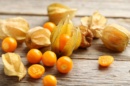 Photo de plusieurs physalis déposés sur une surface en bois.