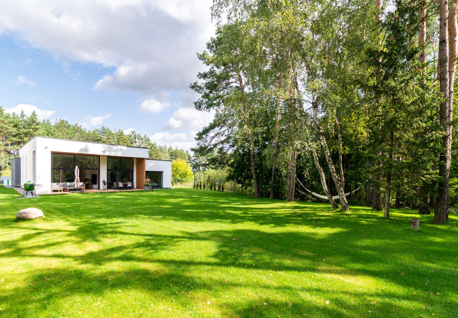Photo d'un jardin agrémenté de gazon avec un maison morderne.